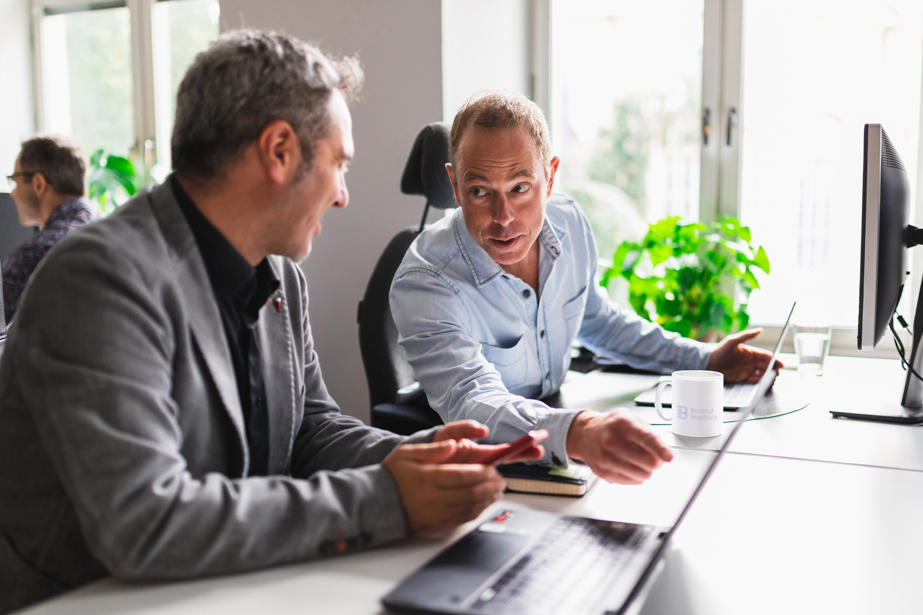 Two men in front of computer working